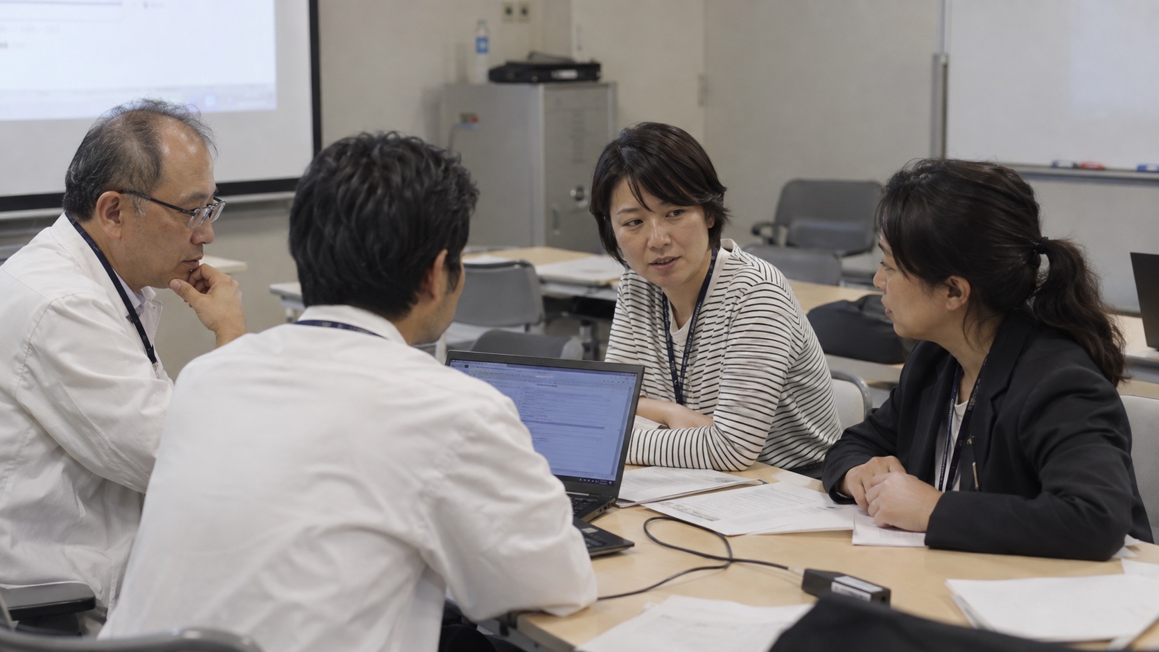 医師たちが勉強会でパソコンを囲み、試作について話し合うイメージ